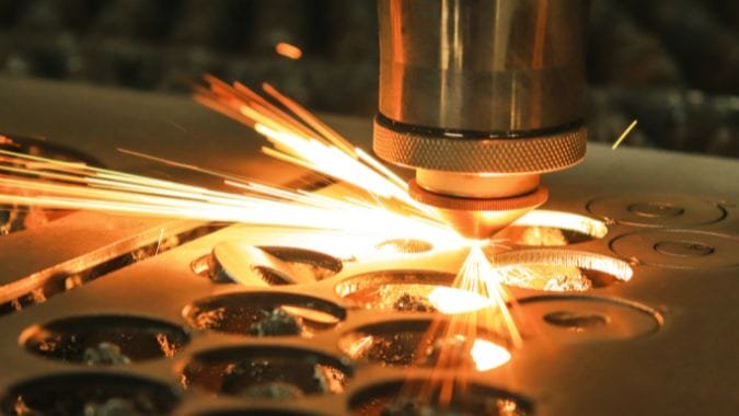 A fiber laser cutter in action on a sheet of steel