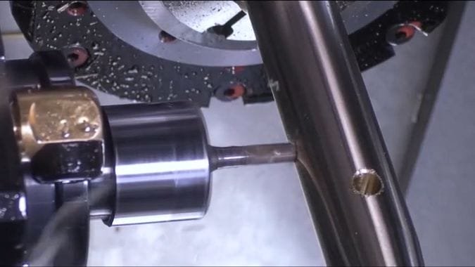 Una testa dell'utensile viva che esegue un foro perfettamente perpendicolare su un pezzo da lavorare