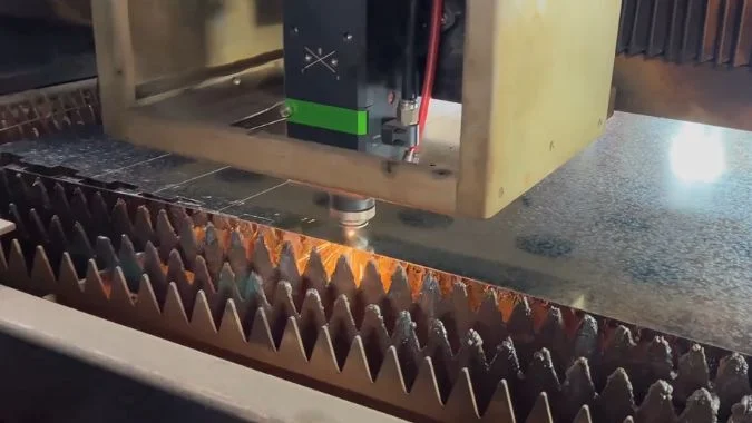 Fiber laser cutter machining a metal sheet