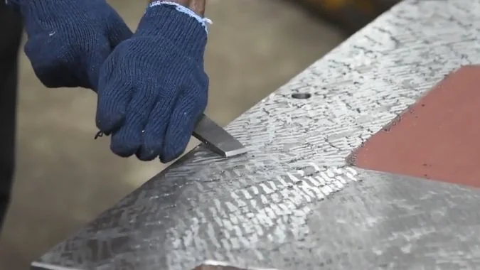 Close up of Worker Scraping the VMC parts