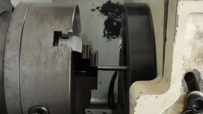 Chuck-held workpiece extending into a thread whirling cutter ring