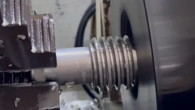 Externally threaded workpiece passing through a thread whirling cutter ring