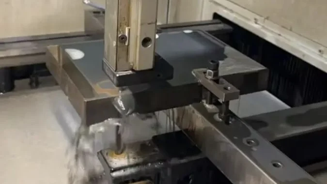 Metal workpiece being cut on a medium-speed wire EDM machine